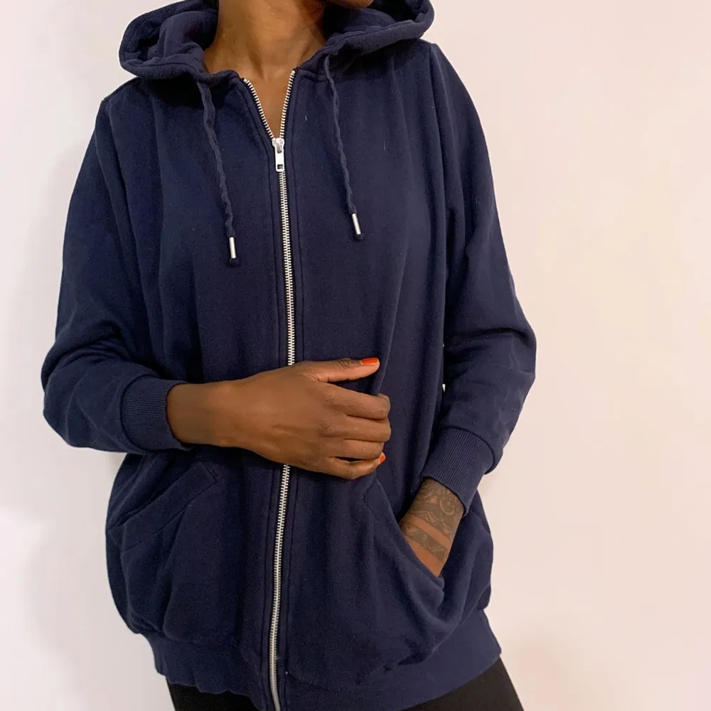 Mörkblå hoodie från Monki med zip i fram och texten 