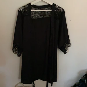 Svart morgonrock med spets - Svart morgonrock från hm. Den har spets längst ut på armarna och även runt axelpartiet. Den har ett band som man kan knyta i midjan. Säljer pågrund av att jag köpt en ny som jag gillar mer😊