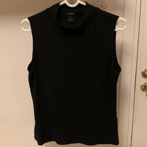 Svart linne med halvpolo i strl M - Ett helt oanvänt linne med halvpolo i storlek M från Lindex. Betalning endast med Swish. Jag står inte för frakt eller postens slarv🥰
