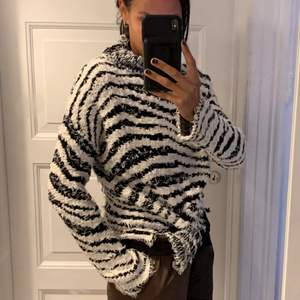 Zebrastribet højhalset sweater. Pasformen er boxy og materialet er super blødt