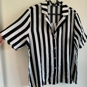 Randig kortärmad skjorta - En helt ny randig kortärmad skjorta från Gina Tricot för ca 1 år sen. Aldrig använd, endast testad. Storlek 40 och har tunt material som passar perfekt på sommaren