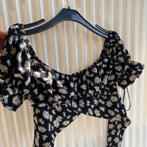 Blommig topp SHEIN  - Superfin topp från SHEIN!! Den har knytband som man kan knyta både bak och fram. Lite puffärm och man kan välja om den ska sitta på axlarna eller som en offshouler. Nyskick!!