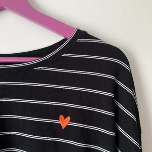 Långärmad t-shirt  - Ett litet broderat hjärta på bröstet. Texten "enjoy" på baksidan. 