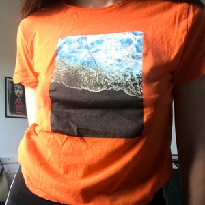 T-shirt  - Orange T-shirt med tryck, använd 1-2 gånger. Storlek är XS men passar XS-M då det är herrstorlek. 