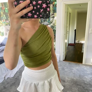 One shoulder linne - Oanvänt linne i mörkgrön, nästan glittrig färg. 