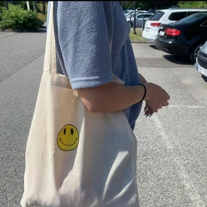 Tygkassar m tryck  - Säljer dessa tygkassar med tryck. Det finns två st att välja mellan (smiley eller ”not shy” ) måttet är 38x40