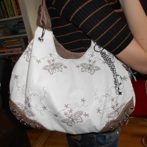 Vit och brun läderväska med fjärilar 🦋 - Köpte denna väska ca 2010 och har aldrig använt den. Superfräsch och i nyskick. Gjord av riktigt läder och har såå fina broderier! Axelrem tillkommer, medium storlek. 🦋💋