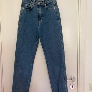 Snygga mörkblåa slim mom jeans från PULL&BEAR i storlek 32. Passar för någon runt 155 cm lång eller längre om man vill ha ankellängd. De är i bra skick men ser lite använda ut på vissa ställen om man kollar noggrant. Detalj (en våg) på båda bakfickorna:)