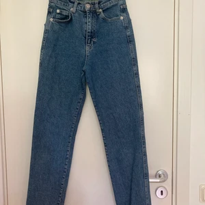 PULL&BEAR slim mom jeans strl 32 mörkblå - Snygga mörkblåa slim mom jeans från PULL&BEAR i storlek 32. Passar för någon runt 155 cm lång eller längre om man vill ha ankellängd. De är i bra skick men ser lite använda ut på vissa ställen om man kollar noggrant. Detalj (en våg) på båda bakfickorna:)