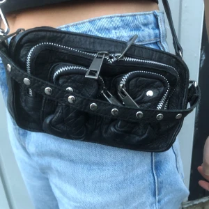 Nunoo - Nunoo väska. Väl använd men inga synliga skavanker. Ingår både långt svart läderband + liten silverkedja. Köparen står för frakt alt. mötas upp i Stockholm. Säljs billigare vid snabbt köpt