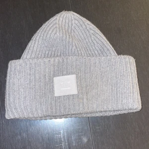 Acne Mössa GRÅ - Mössan är grå men själva märket är en lite ljusare färg. NO SIZE och även unisex. Köp 2020 och mycket bra skick. Inget kvitto men har förpackningen till mössan. Köpte den för 1100kr på Acnes egna hemsida.