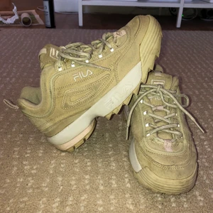 FILA DISRUPTOR LOW BEIGE MOCKA - Säljer mina FILA DISRUPTOR LOW i beige i mocka i storlek 37. Generellt är dessa skor lite mindre i storleken och de passar mig bra som normalt har storlek 36. Skorna är använda, men rengjorda och generellt i bra skick. Dock är mockan lite fläckig, men inget som inte kan tvättas. Köptes för omkring 1200 kr.