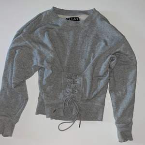 Säljer en grå långärmad tröja lite varmare med ett snöre som är snörat o knytet i storlek s från märket stay för 80 kr