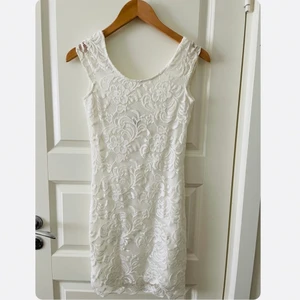 Klänning - Säljer en vit fin spetsklänning i stl 34. Tyvärr aldrig använd därav finns prislappen kvar på plagget. Klänningen är även lite öppen med ett ”djup” som går ner längs ryggen. Går även att frakta.