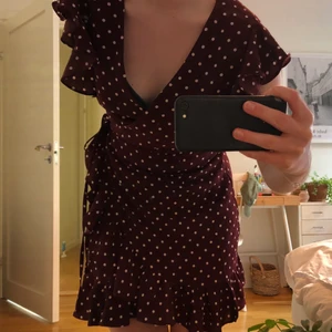 Klänning med volanger  - Så söt klänning i en vinröd färg med vita prickar. Köpt på Nelly för några år sen, använd några enstaka gånger. Klänningen har volanger nertill och vid armarna! 