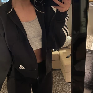 Svart Adidas kofta  - Jag säljer denna fina svarta adidas kofta i storlek xs. Den är i mycket bra skick då den inte använts mer än nån gång. Den är kroppad och jätteskön. 