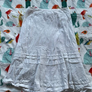 Vit volangkjol - En kjol som sträcker sig till precis över knäna, passar tillfällen där man inte vill ha en kort kjol men ändå vill va uppklädd så fin på sommaren med ett linne eller ha en hoodie över, gulliga volanger