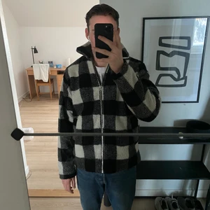 Rutig pilé jacka, Stl M - Säljer en rutig pilé jacka från Carlings i nyskick. Storleken är medium och han som har på sig jackan är 183cm. Vid fler frågor och funderingar så är det bara att skicka iväg ett meddelande!