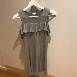 En grå klänning till lite över knät. Knappt använd och säljer eftersom en är för liten.