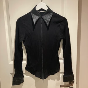 Vintage tröja  - Snygg svart vintage tröja med läder vid kragen o ärmarna (kan va fake läder är inte säker hehe). Mkt stretchig så passar allt från s-l, det står strl 42 men den är liten i storleken. Sliten på insidan av dragkedjan men inget som påverkar hur dragkedjan funkar och inget som syns när man har på sig tröjan! 