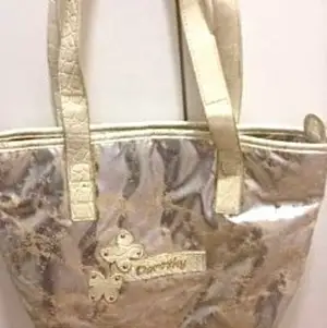 Dorothy Perkins väska i guldmetallic mått 34*23 cm . Aldrig använd 