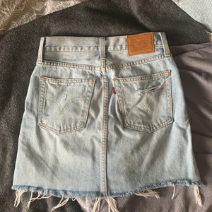 Levis jeanskjol - Säljer denna fina jeanskjolen från Levis, då den är för liten❣️ Köpte den förra sommaren för ungefär 600kr.  Kjolen är i storlek 24 som motsvarar  storlek 32 och XS. Pris kan diskuteras☺️