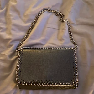 Tiamo liknande svart väska - Svart, snygg väska. Liknar tiamo väska väldigt mycket. Väskan har en lång kedja men den kan göras kortare så man kan använda väskan som en trendig axel-väska. Köpt på ullared för något år sedan och använd sparsamt. inga fläckar och är i princip i nyskick. Frakten ingår i priset!! Tveka inte vid frågor🥰 Priset kan diskuteras