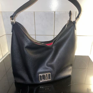 Love mochino - Love mochino väska, säljer den för att jag har försökt att tycka om den men det är inte min stil, har lite svårt för det stora LM märket, men någon annan kanske tycker om den ☺️ skickas per post, spårbart, köparen står för frakten 🌸 betalning via swish.