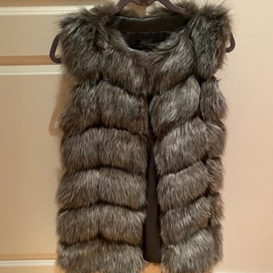 Fake päls väst  - Fake päls väst - oanvänd (helt ny skick) Mörkare grå färg. Storlek S-M