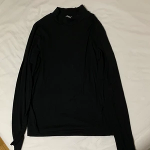 Svart polotröja från Lindex - Svart stretchig polotröja från Lindex med låg krage, den är i storlek L men skulle säga att den även passar storlek XL! Använd men i bra skick! Du betalar priset(150kr)+frakt