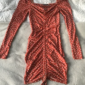 Kopparfärgad prickig klänning  - Jättefin prickig klänning, storlek 34. Superfin nu till hösten med ett par höga boots. 