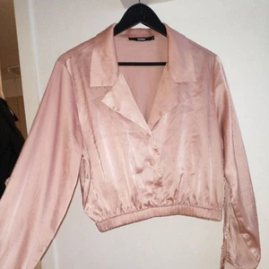 Rosa skjorta, glansigt tyg (kort)  - Ligger även ute på tise. Priset kan diskuteras. Från BikBok