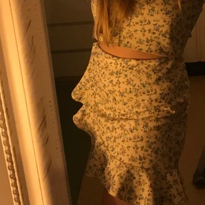 Kjol set från Nelly - Ett superfint klädset från Nelly med en kjol i gulfärg med blommor & en croptop i samma motiv.          Kjol storlek: M Croptop storlek: L.                         Säljer pga för stort (ej använt)                     Orginalpris: 399kr