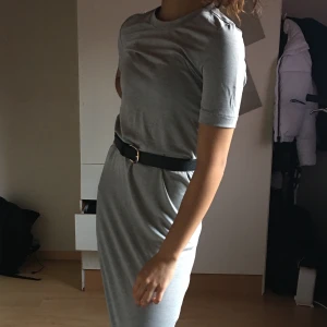 Tajt lång klänning - Köpt från Weekday, storlek Xs, grå lång klänning, både skön och fin, superfin med ett bälte i midjan, ganska tajt på mig som är hyfsat så liten!!