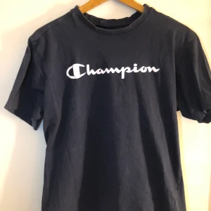 Marinblå champion tshirt - En vintage champion T-shirt i en marinblå färg, vilket inte riktigt framgår på bilden. Superskön! Storlek M men skulle säga att den är lite liten i storleken så funkar även på en S