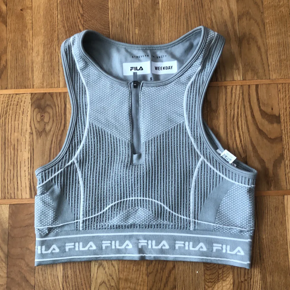 Sporty crop-top from the Fila x Weekday collection. Can be worn as workout clothes but also as fashion-wear. Zipper in the front. Fits a size S. Can be bought as a set with matching biker shorts.. Toppar.