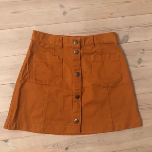 Kjol Monki rostfärgad hög midja storlek 38 - Säljer denna fina kjol från monki i storlek 38 (men passar även mig med 36 perfekt). Den har fickor och knäppa längst fram. Kjolen är i mycket gott skick. Skickas spårbart eller möts upp!