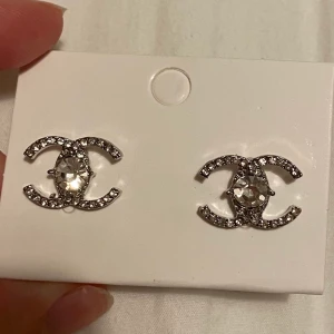 Säljer Chanel örhängen  - Säljer dessa oanvända Chanel örhängen. Det är en kopia. Har stämpeln 925, så antar det är silver. Undrar man över något så är det bara att kontakta mig. Pris går att diskutera.