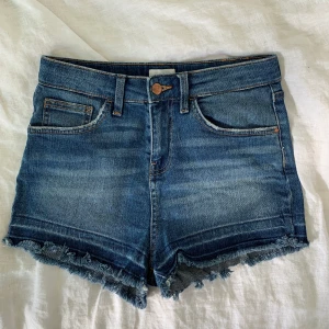 River Island shorts strl 36 - Snygga korta shorts från River Island i storlek 36. Ett par vanliga jeanshorts med dragkedja och fransar längs kanten. Dom är i fint skick. Köparen står för frakten.