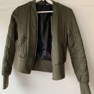 Grön bomberjacka  - En snygg grön bomberjacka från HM Divided i storlek 32. Den är använd men i fint skick och inga slitningar. Används nu inte längre för att jag bytt stil och vill att den kommer till användning hos någon annan💕💕