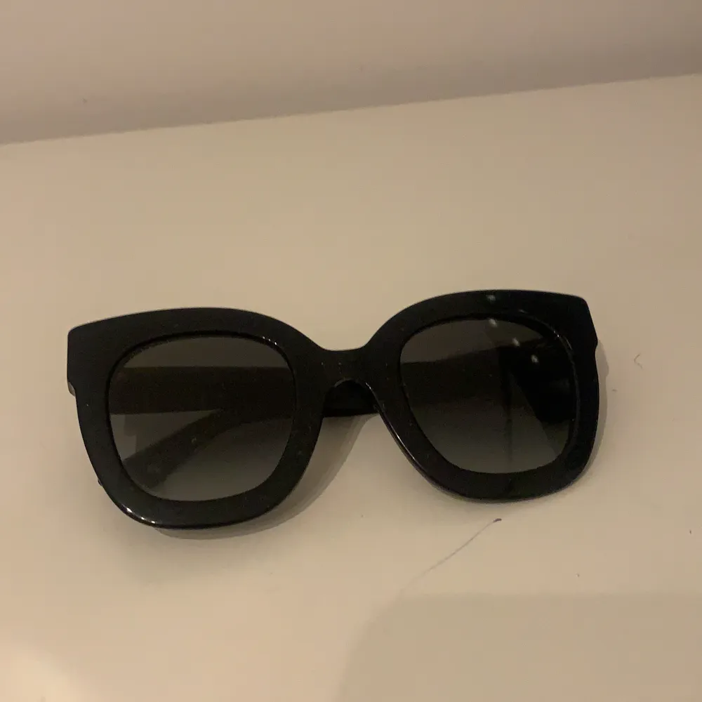 Äkta svarta Gucci solglasögon med detaljer på sidorna. Solglasögonen är i superbra skick och perfekta för den kommande sommaren! Köpt för 3500 kr. Fodral medföljer.. Övrigt.