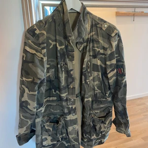 Kamouflerad Jacka - Kamouflerad jacka,  Text på baksidan. 300 inklusive frakt 🥰 skulle säga att den både passar killar och tjejer. Är i storlek L men passar mig som är S-M 