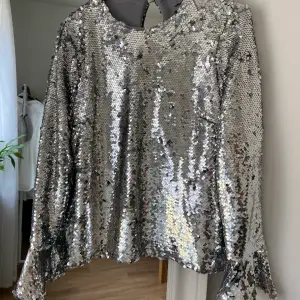 Supersnygg paljettblus från Topshop UNIQUE! Peplum på ärmen, bak i ryggen som också är öppen. Lappar bortklippta men det är definitivt Topshop. Super fin kvalite! Spänne bak i nacken lite löst men kan sys fast mer. Använd EN gång så i fint skick!