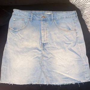 Blå jeanskjol - Blå jeanskjol i avklippt modell från Gina Tricot. Stretchigt material! Storlek 44. Knappt använd.