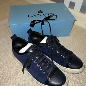 Lanvin sneakers - Lanvin sneakers i mocka och läder, färgen navyblue. Använda ett fåtal gånger så i bra skick. Nypris ca 3900 kr, säljes med box, tygpåse och exktra vita skosnören. Skriv gärna vid funderingar eller om fler bilder önskas :)