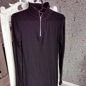 Ribbad klänning xs - Svart ribbad klänning med krage och dragkedja. Använd vid ett tillfälle.                                    Köparen står för eventuell frakt, skickar med billigaste alternativet eller annat enligt önskemål ☺️