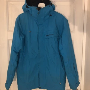 Peak performance skidjacka - En jättesnygg fodrad blå skidjacka som tyvärr är för liten för mig. Asymmetriska fickor och en luva som hjälmen får plats i, ficka på vänsterarmen för liftkort. Snygg i backen eller bara på stan. Vind och vattentålig.