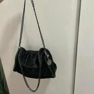 Väska - Svart Stella McCartney liknande väska. Kedjan är mörkgrå/mörksilver. Kan mötas upp i Jönköping annars tillkommer fraktkostnad🤍