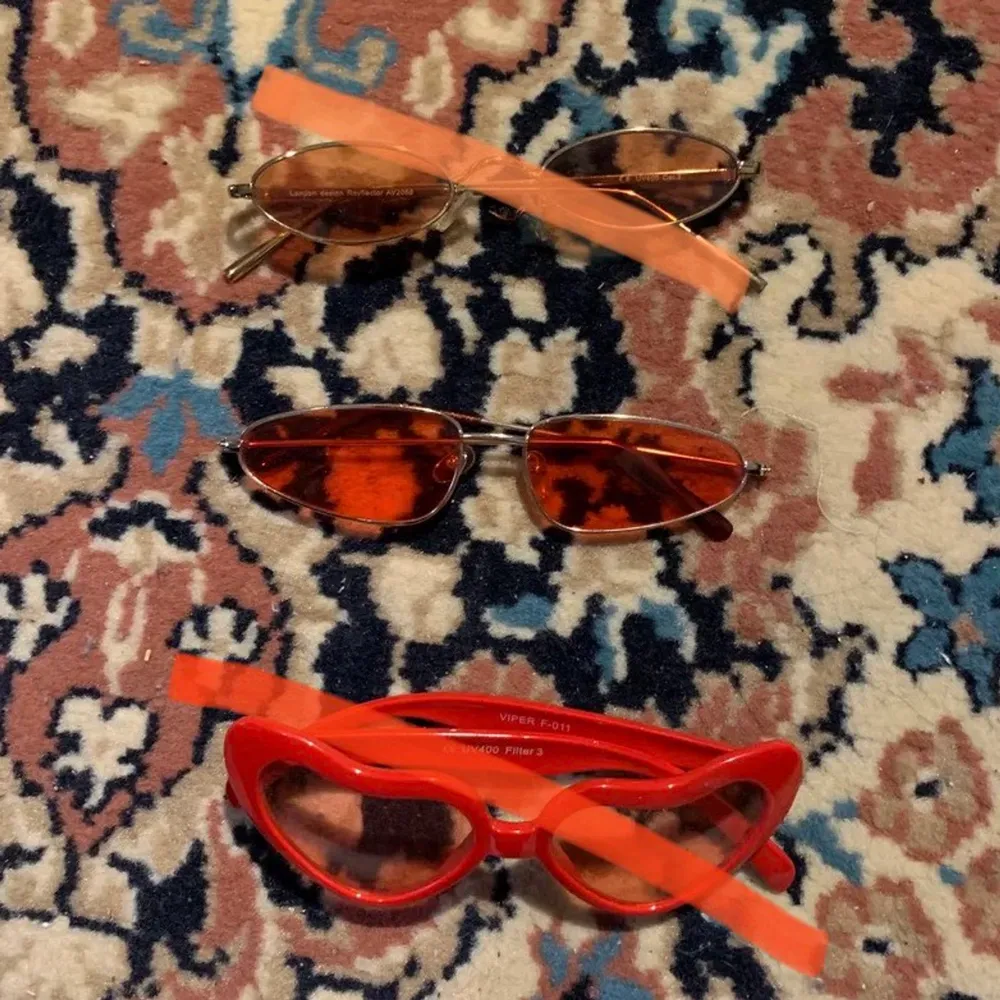 3 par solglasögon, ett par ovala orange/bruna med guldig ram, ett par lite mer kantiga röda med guldig ram och ett par hjärtformade röda med röd/rosa glas ❣️ Solglasögonen säljs separat för 20 kr/st!. Accessoarer.