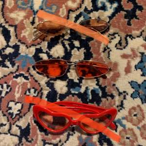 3 par solglasögon, ett par ovala orange/bruna med guldig ram, ett par lite mer kantiga röda med guldig ram och ett par hjärtformade röda med röd/rosa glas ❣️ Solglasögonen säljs separat för 20 kr/st!